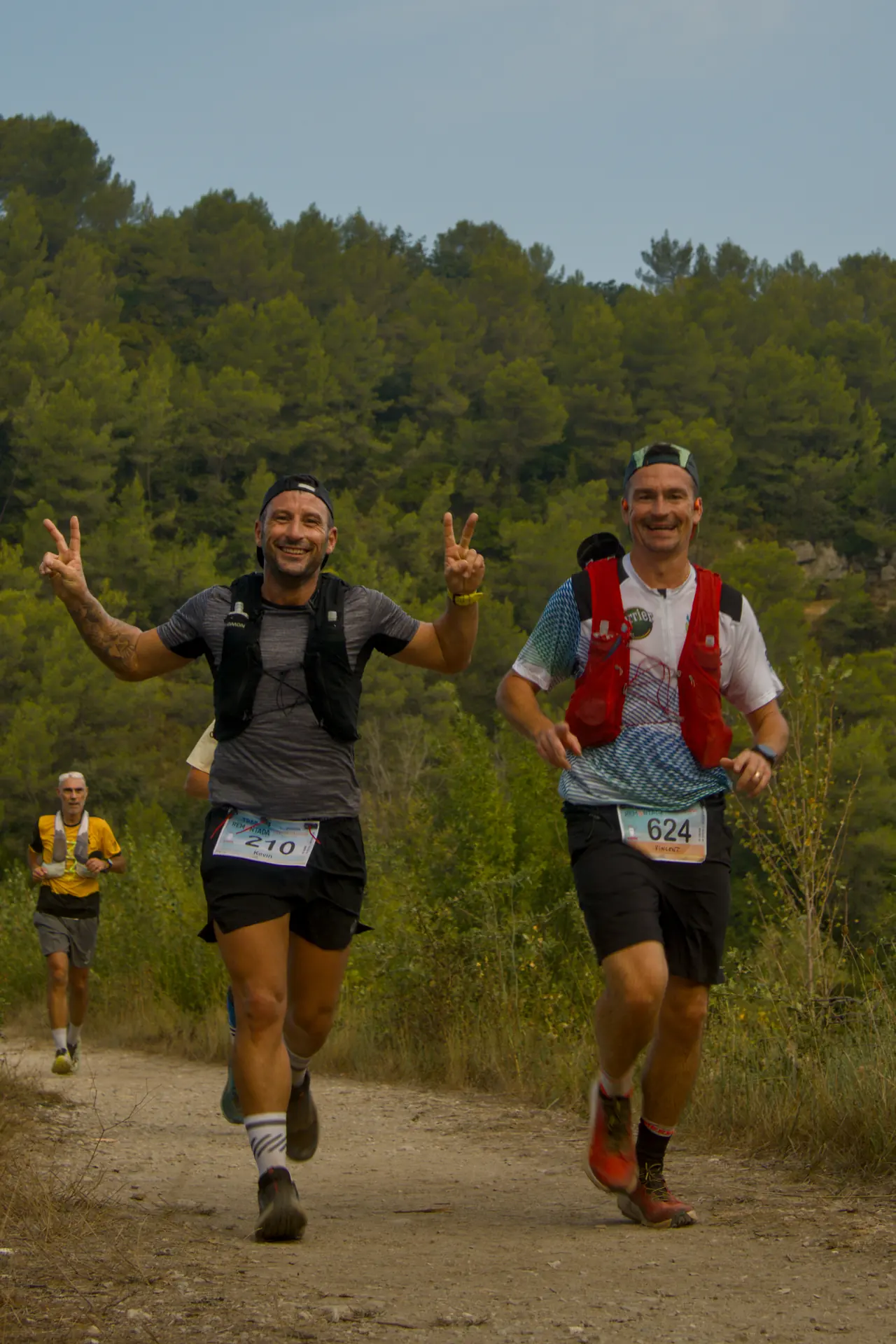 Deux coureurs hilares, l’un fait le V de la victoire des deux mains.