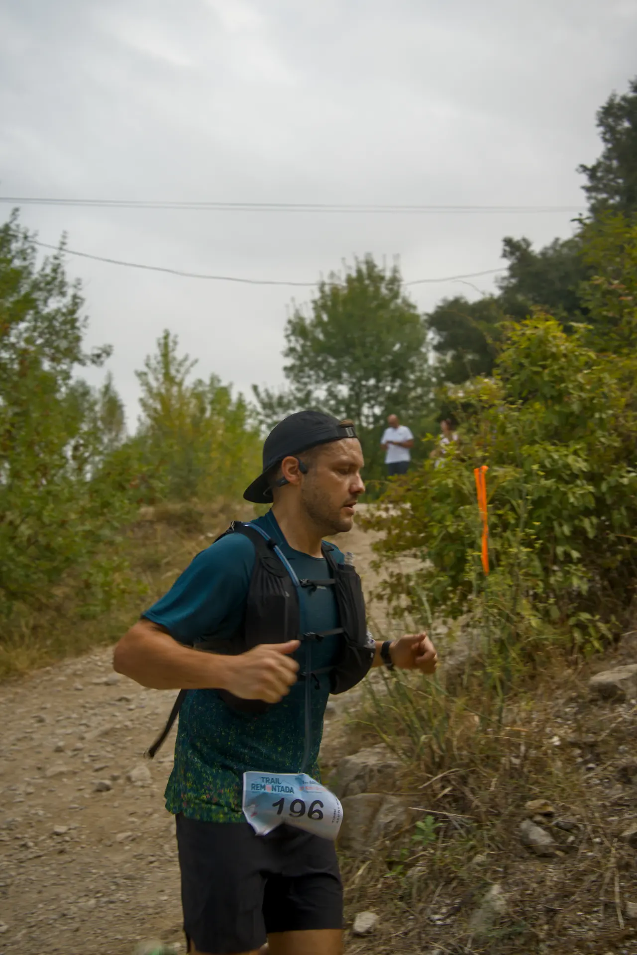 Un coureur, casquette à l’envers, passe en plein effort tout près de l’objectif.
