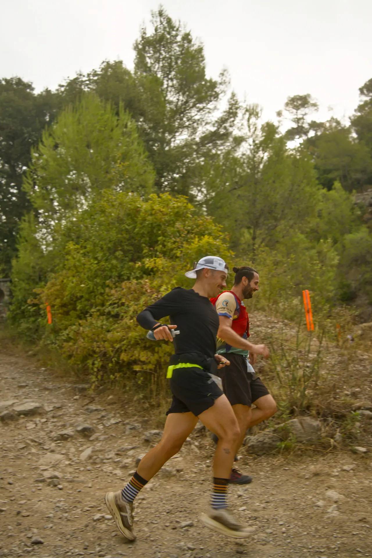 Deux coureurs lancés dans une descente caillouteuse.